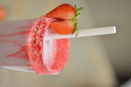 Strawberry smoothie on a stick in a white plastic cupの写真素材