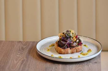 Grilled liver served on toast with mustard and microgreens