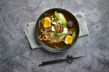 Japanese miso soup with vegetables, mushrooms and egg in a bowlの写真素材