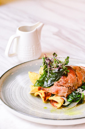 rabbit leg with spinach and parmesan on a plateの写真素材