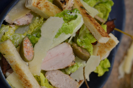 Caesar salad with ham, cheese, olives and croutonsの写真素材