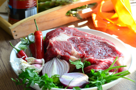 raw beef steak with red hot chili pepper, parsley and garlicの写真素材