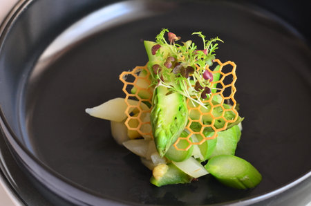 Vegetable salad with asparagus and radish in black plateの写真素材
