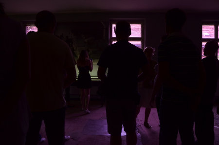 Silhouette of a group of people in a dark room at nightの写真素材