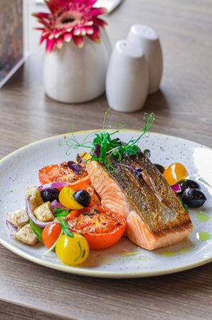 fresh grilled salmon steak with vegetables on white plateの写真素材