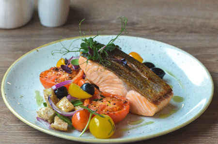 fresh grilled salmon steak with vegetables on white plateの写真素材