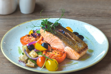fresh grilled salmon steak with vegetables on white plateの写真素材