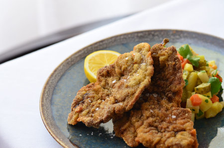 Schnitzel with salad in a plate on the table.