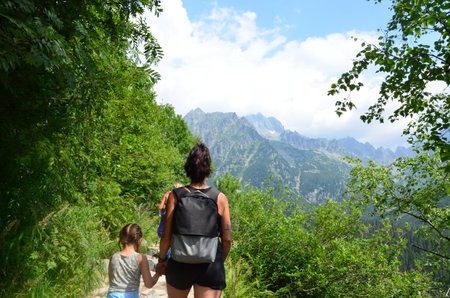 Mother and daughter hiking in the mountains at summer day. Family travelの写真素材