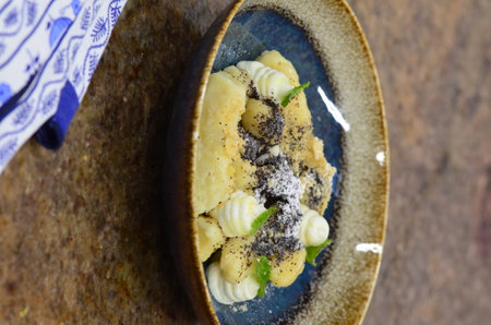 Baked sweet potato gnocchi with black poppy seeds on plateの写真素材