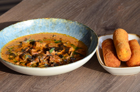 goulash with mushroom in a bowl on wooden tableの写真素材