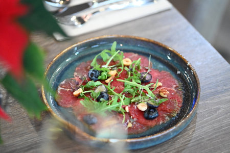 Beef carpaccio with arugula, blueberries and pine nutsの写真素材