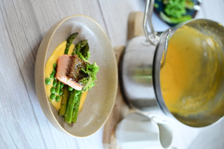 Green asparagus salad with salmon and mango sauce on wooden tableの写真素材
