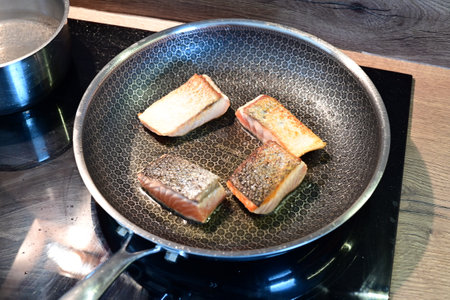 Slices of salmon on a frying pan. Selective focus.の写真素材
