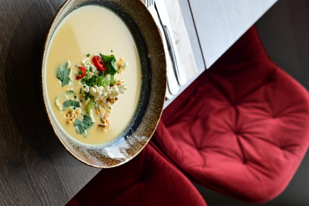 Vibrant Yellow Corn Soup with Popcorn, Chili, and Cilantro â Restaurant Servingの写真素材
