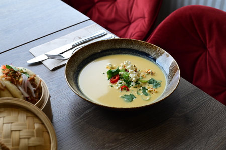 Vibrant Yellow Corn Soup with Popcorn, Chili, and Cilantro â Restaurant Servingの写真素材