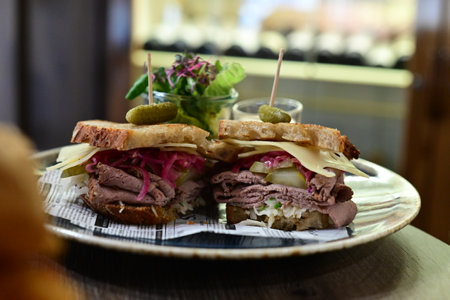sandwich with roast beef and pickled cucumber on wooden tableの写真素材