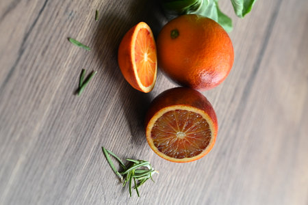 Slices of orange and rosemary on wooden table, closeupの写真素材