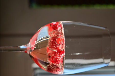 Wine glass with raspberries on the table