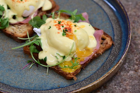 Eggs benedict with hollandaise sauce on toast