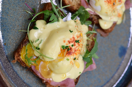 Eggs benedict with hollandaise sauce on toast