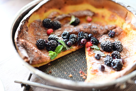 Cottage cheese pancakes with blackberries and raspberries in a baking pan