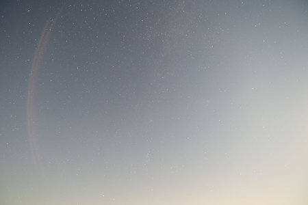 Night sky with stars and a rainbow in the foreground. Space background