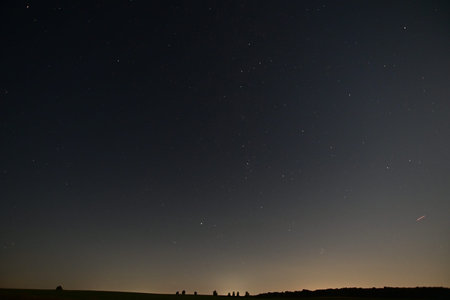 Night sky with stars and a milky way over the field.