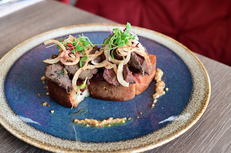 Close-up of toasted bread topped with rich goose liver pâté, highlighting texture, color, and gourmet presentation, perfect for culinary and food photography.の写真素材