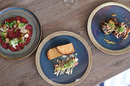 Top view of three plates of food served on wooden table