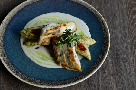 grilled fish fillet with mashed potatoes and sauce on a plate