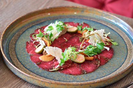 Beef carpaccio with vegetables and parmesan on a plate
