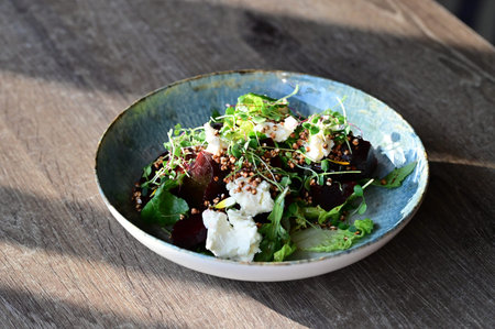 Close-up view of a freshly served salad on a restaurant table. A healthy and colorful mix of...