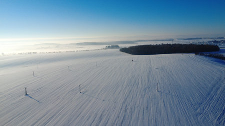 Aerial view of snow covered field in winter. Beautiful winter landscape.