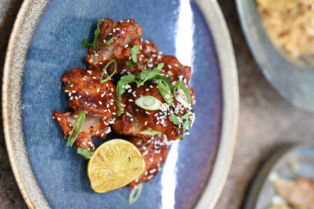 Fried pork ribs with sesame seeds and lemon on a plate