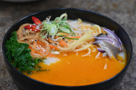 spicy noodle soup in black bowl