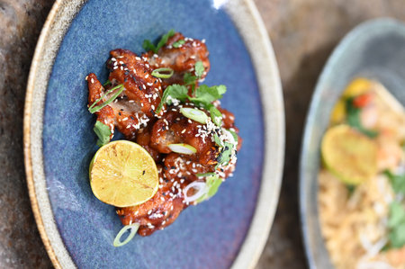 chicken teriyaki with lemon and sesame seeds on plateの写真素材