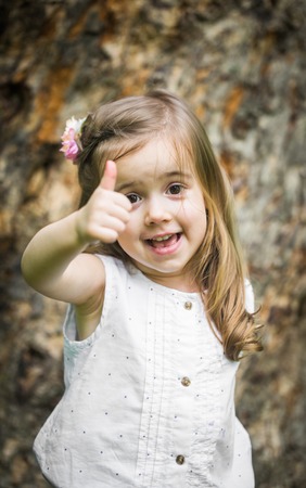 happy girl shows gesture cool, on wood backgroundの写真素材