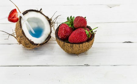 fresh, delicious coconut with strawberries on white wooden background tasty dessertの写真素材
