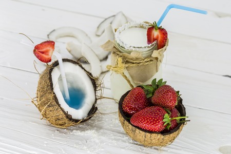 fresh, delicious coconut with strawberries on white wooden background tasty dessertの写真素材