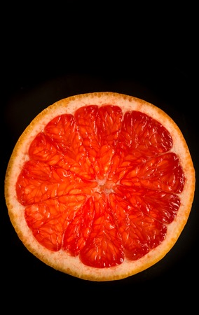 cut grapefruit, citrus on black background, foodの写真素材