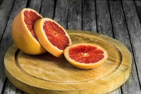 cut grapefruit on a wooden Board, citrus on wooden backgroundの写真素材