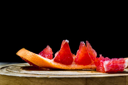 cut grapefruit, citrus on black background, food
