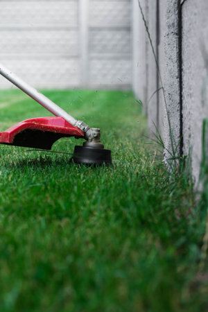 manual lawn mower on the background of green grass, cut grass in not accessible places