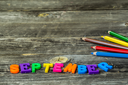 school supplies on wooden background, Notepad, pencils with the word Septemberの写真素材