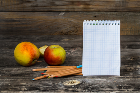 school supplies on wooden background, Notepad, pencils and applesの写真素材