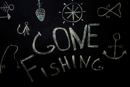fishing,inscription in chalk on a black background,fishing accessoriesの写真素材