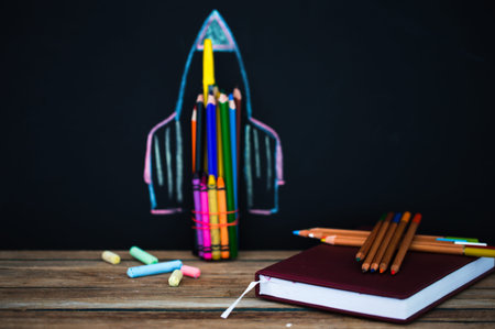 Back to school black background the missile made with pencils, drawing with crayons school