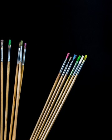 paint brushes of different colors on a black backgroundの写真素材