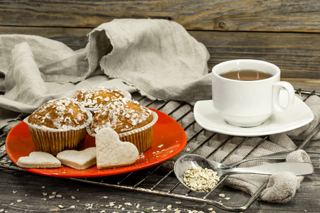 beautiful cupcakes with berries on wooden background in red plate,pichenki in the shape of heartsの写真素材
